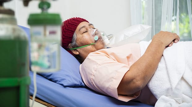Asian elderly woman wearing wool hat with oxygen mask to breathing while  lying on patient bed, senior female medical and healthcare concept
